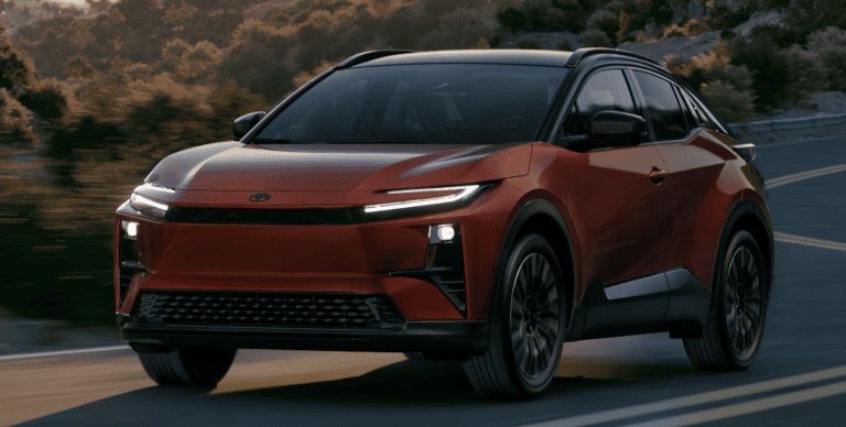 red 2026 Toyota c-hr all electric driving down highway